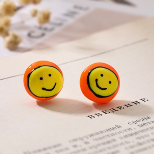 Boucles d'oreilles rondes dorées avec émail orange et motif visage sourire jaune
