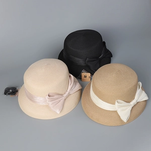 Vista dettagliata di cappelli di paglia in beige, marrone e nero con fiocchi di seta