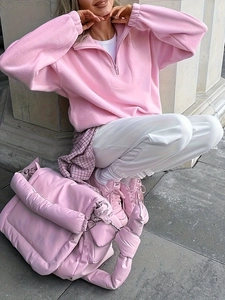 Outdoor lifestyle shot of a pink puffy quilted bag with matching fleece sweatshirt