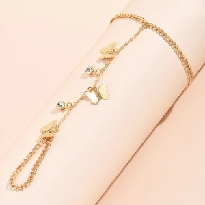 Close-up of golden slave bracelet with butterfly charms and rhinestones on model hand