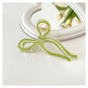 Detail view of 11cm avocado green jelly bow hair claw clip on a white surface