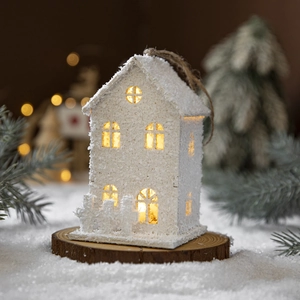 White LED Christmas snow house ornament on wooden base with festive pine branch decor