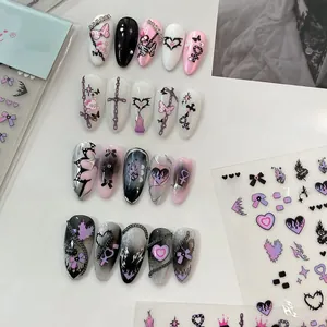 Detail view of gothic style press-on nails with 3D metal chains and Y2K butterfly designs