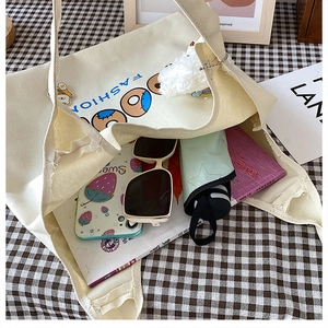 Draufsicht der cremefarbenen Canvas-Tasche mit geräumigem Innenfach für Bücher und Zubehör