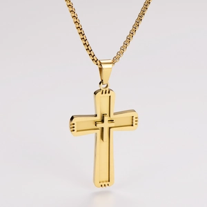 Macro detail of golden stainless steel double-layered cross pendant with box chain
