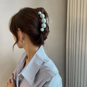 Détail d'une pince à cheveux avec perles bleu clair sur un modèle au style élégant