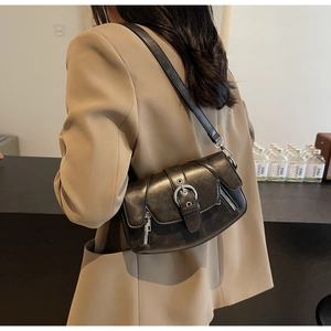 Detail of vintage black leather saddle bag with silver round buckle and side zipper
