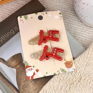 Detail of red reindeer hair clips with white snowflake embroidery on a festive card