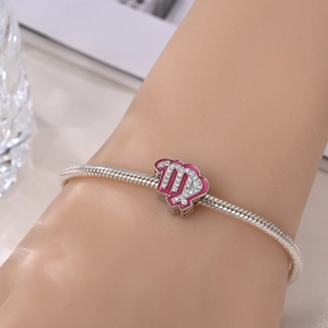 Close-up of Virgo zodiac charm with pink enamel and zircons on silver snake chain