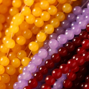 Macro shot of 8mm yellow, purple, and agate red glass beads with a glossy finish