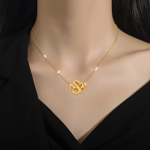 Elegant gold-plated double swan heart necklace on model with black V-neck top