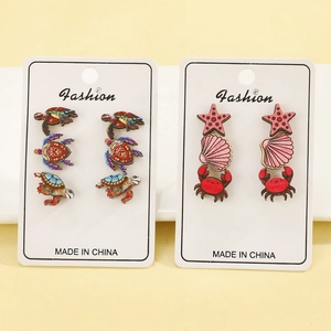 Mediterranean sea turtle and crab wooden stud earring set on a fashion display card