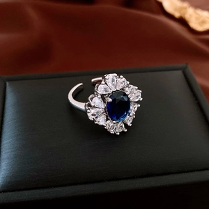 Macro shot of French court style teardrop zircon ring with blue oval main stone