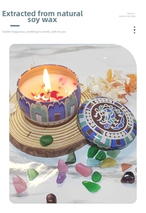 Detail of natural soy wax candle with dried flowers in a bohemian patterned tin box