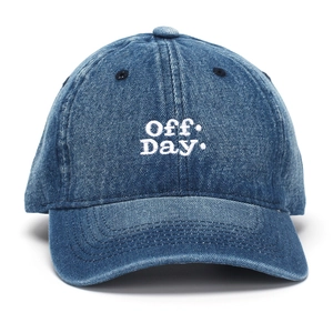 Detail of Off Day white embroidery on a washed denim blue baseball cap crown