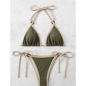 Olive green two-piece bikini with beige trim and tortoise ring accents on marble background
