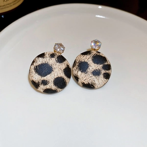 Close-up of leopard print round earrings with golden finish and clear zircon inlay