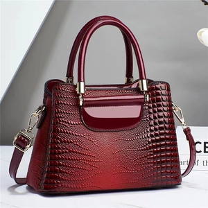 Glossy red crocodile embossed bucket bag with gold hardware and top handles