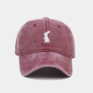 Detailed embroidery of white rabbit on vintage washed burgundy cotton baseball cap texture