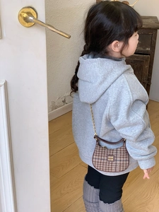 Détail d'un sac à carreaux pour enfants avec bordure en cuir et chaîne dorée