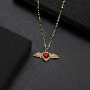 Close-up of a red heart pendant necklace with gold wings and zircon on a black leather gift box