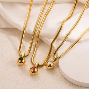 Three gold snake chain necklaces with green red and clear gemstone ball pendants