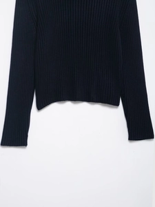 Macro shot of dark navy ribbed knit texture showing hem and cuff detail of long sleeve top