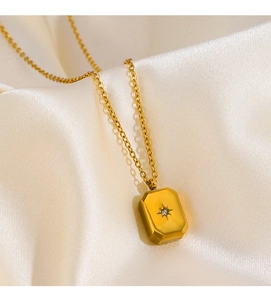 Detailed shot of gold rectangle starburst pendant with crystal on satin background
