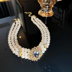 Macro view of triple-strand pearl choker with a large rhinestone oval pendant detail