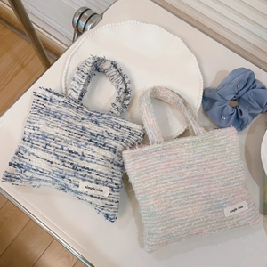 Dettaglio di mini borse tote in tweed intrecciato arcobaleno e a quadretti blu con etichetta