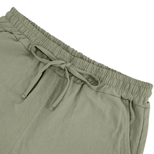 Detailed view of elastic drawstring waistband and linen fabric texture on beach shorts