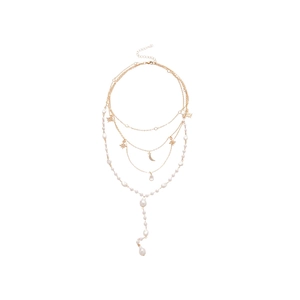 Layered gold necklace featuring star and moon charms with baroque pearl accents on white back