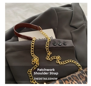 Detail of metal chain and brown leather shoulder strap with leopard print bag texture