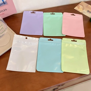 Colorful macaron resealable plastic bags for jewelry and makeup brushes on wooden desk