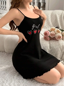 Detailed view of women's black nightgown featuring white letter print and heart pattern