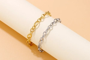 Detail of twisted curb chain link bracelets in gold and silver finish on display stand