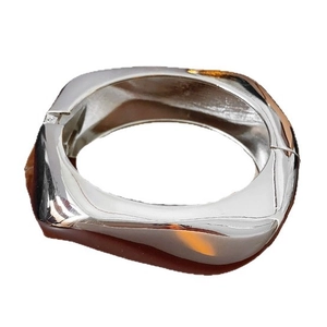 Minimalist irregular wavy silver metal bangle with mirror polished finish and open design