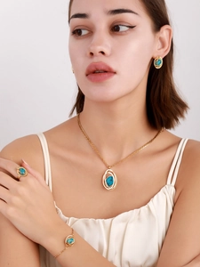 Model wearing golden jewelry set with turquoise stones including necklace and earrings