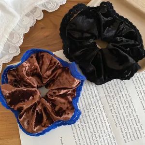 Floral fabric scrunchies in brown and black velvet with lace trim on a wooden background