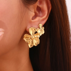 Macro view of a 18K gold plated stainless steel five-petal flower stud earring on ear