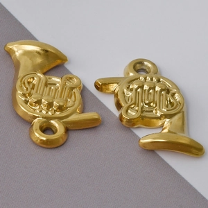 Macro detail of golden French horn pendants in 304 stainless steel for DIY necklace jewelry