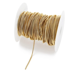 Close-up of 18k gold plated stainless steel box chain roll on white spool for DIY jewelry