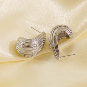 Minimalist silver stainless steel drop earrings with textured stripe design on silk background