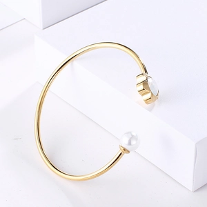 Elegant gold flower cuff bracelet with pearl accent and crystal inlay in 45-degree view