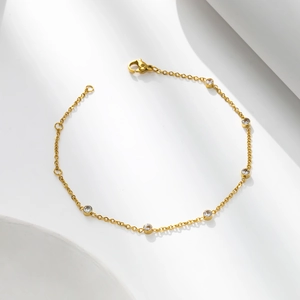 Détail du bracelet en acier titane doré avec six zircons ronds et fermoir mousqueton robuste