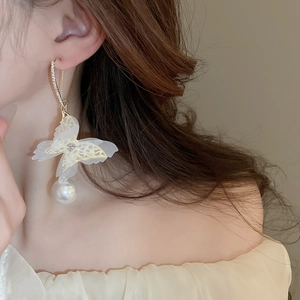 Detailed view of mesh butterfly earring with pearl drop and shimmering crystals