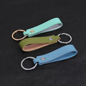 Detailed view of mint green, olive, and blue PU leather keychains with metal rings