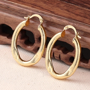 Detail von 18K Gold-Creolen mit gehämmerter Textur und sicherem Schnappverschluss