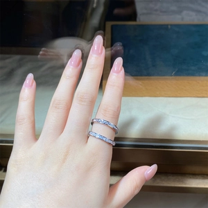 Detail of a double-layered S925 silver ring set with sparkling zircons on a finger
