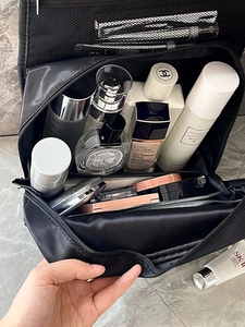 Inside view of black travel cosmetic bag with mesh pockets and large storage space